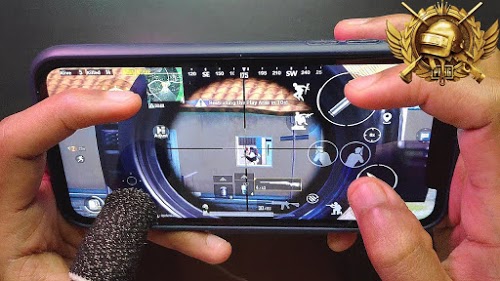 image of two hands holding a mobile phone with a video game on the screen